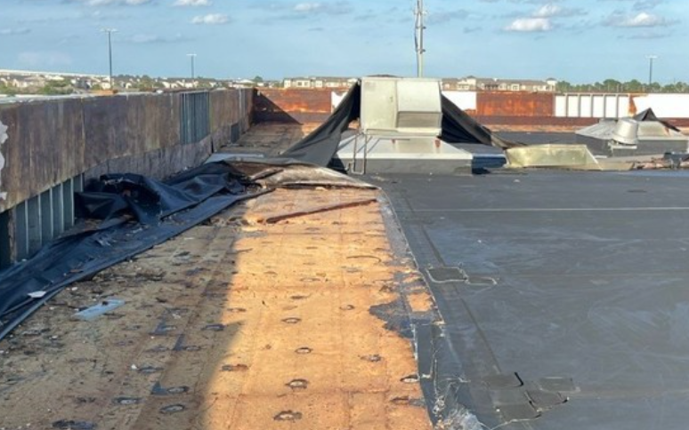 Wind damaged commercial roof installed and repaired by Roof Experts USA.