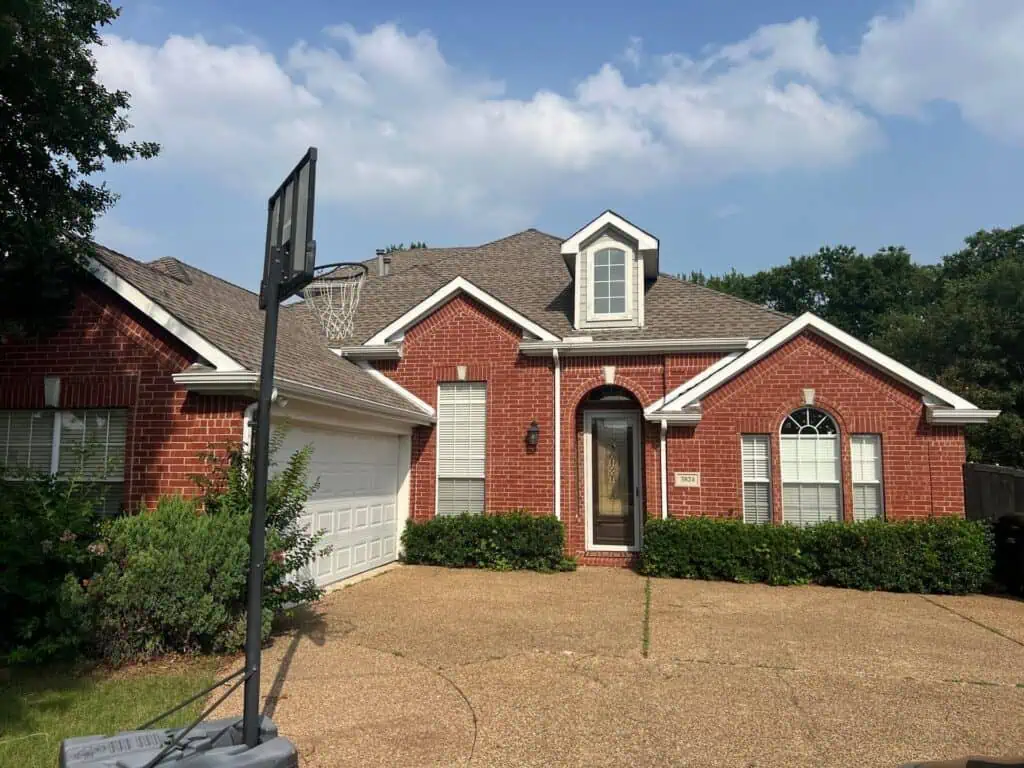 Completed shingle roof on a brick home in Plano, TX